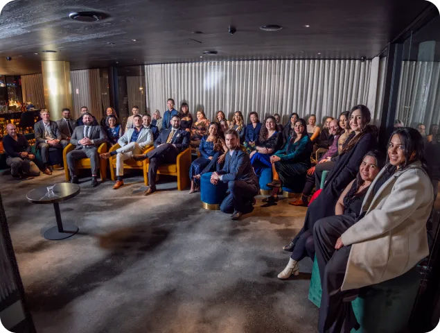 The Unify Disability Services team seated together in a dimly lit function room